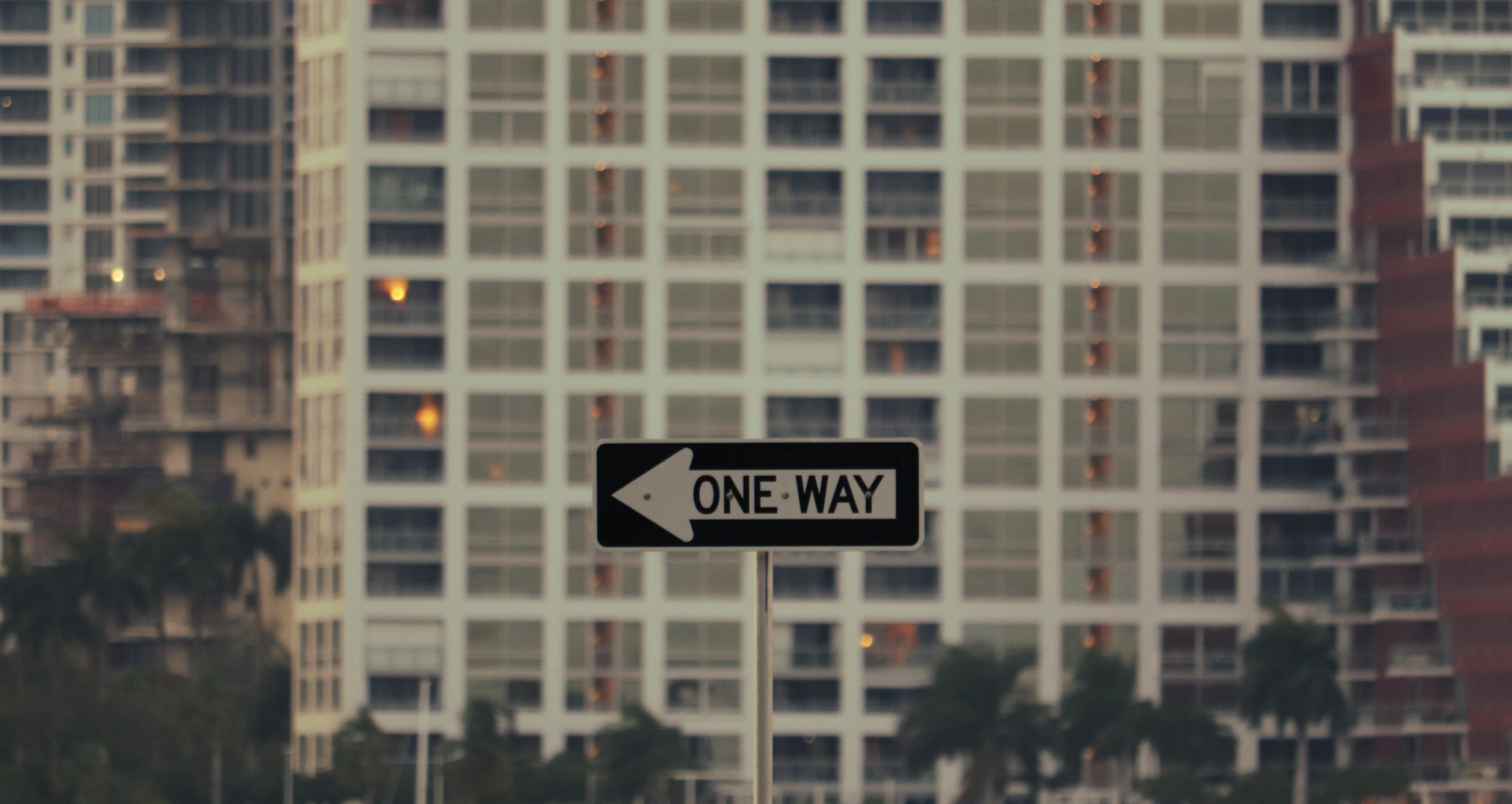 a photographed picture of a one way sign